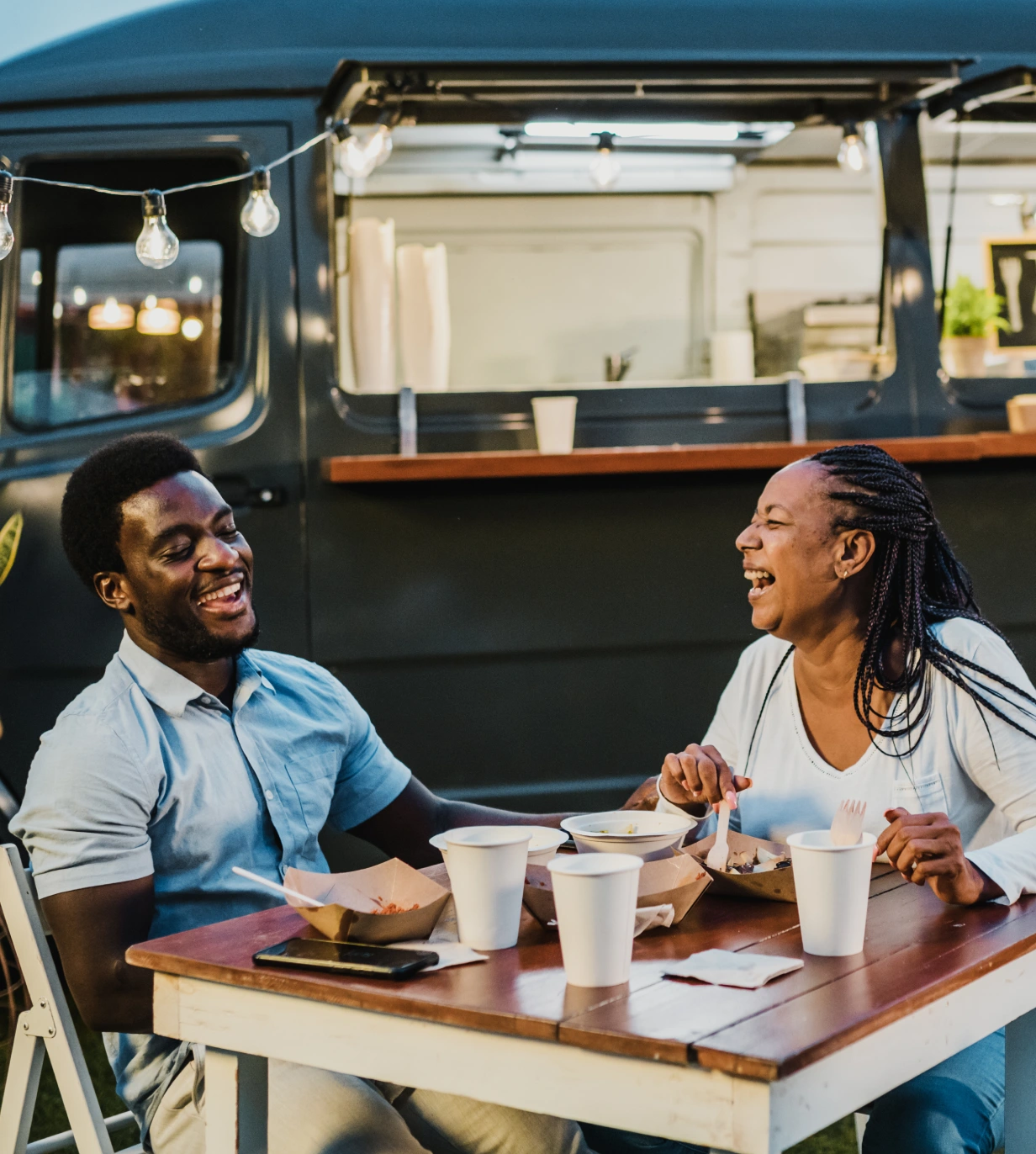 Two people sitting at a table with cups of coffee.